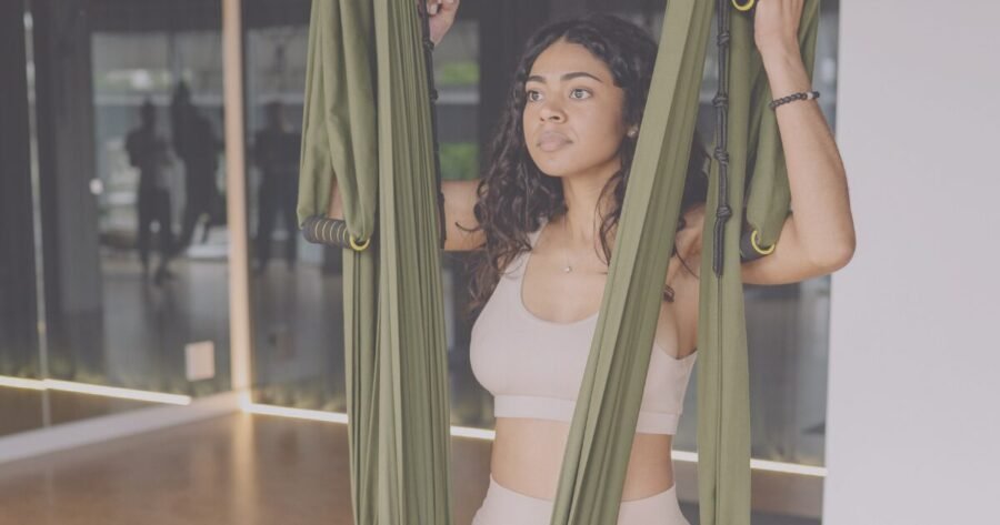 Aerial yoga practitioner demonstrating the benefits of anti-gravity yoga in a silk hammock